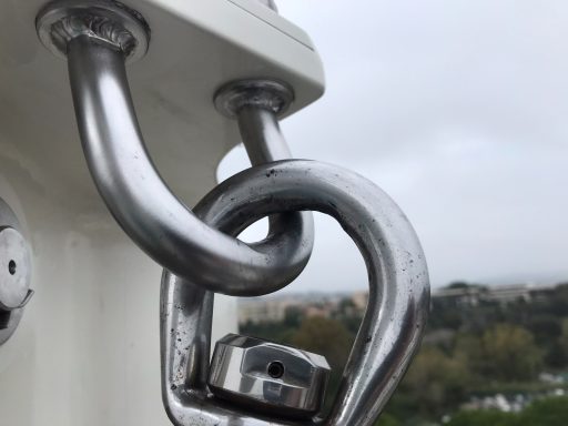 attache inox sur poulie après nettoyage de la rouille , en tête de mat sur voilier